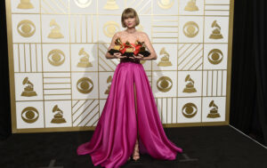 Taylor Swift poses in the press room with the awards for album of the year for 1989, pop vocal album for 1989 and best music video for "Bad Blood" at the 58th annual Grammy Awards at the Staples Center on Monday, Feb. 15, 2016, in Los Angeles. (Photo by Chris Pizzello/Invision/AP)