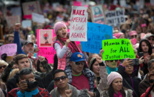 Maya Farias, 7, of San Jose, with her father, Eddie Farias, cheers during the Women's March rally at Plaza de Cesar Chavez Park in downtown San Jose, Calif., Saturday, Jan. 21, 2017. (Patrick Tehan/Bay Area News Group)