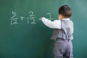 16 Nov 2014, Beijing, China --- Cute baby doing mathematics on blackboard --- Image by © Blue Jean Images/Corbis